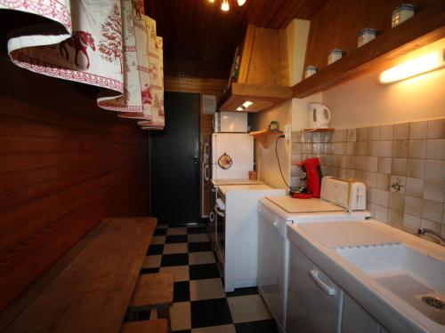 une petite cuisine avec un évier et un réfrigérateur dans l'établissement Charmant 3 pièces au centre avec balcon, garage et proche pistes - 6 couchages - FR-1-572-203, à Arâches-la-Frasse