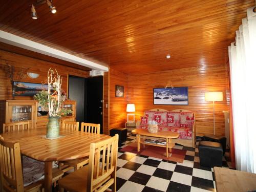 une salle à manger avec une table et un canapé dans l'établissement Charmant 3 pièces au centre avec balcon, garage et proche pistes - 6 couchages - FR-1-572-203, à Arâches-la-Frasse