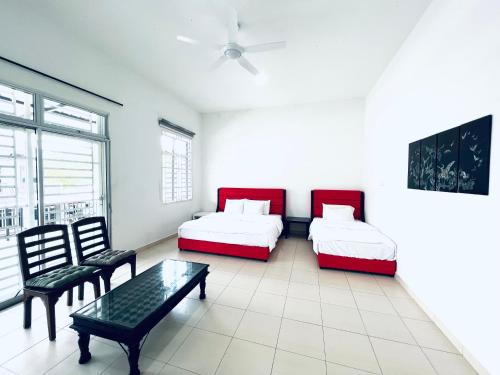 a room with two beds and a table and chairs at SingBeach holiday house in Mersing