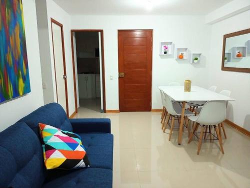 ein Wohnzimmer mit einem blauen Sofa und einem Tisch in der Unterkunft Elegante y acogedor departamento entero # 3 in Víctor Larco Herrera