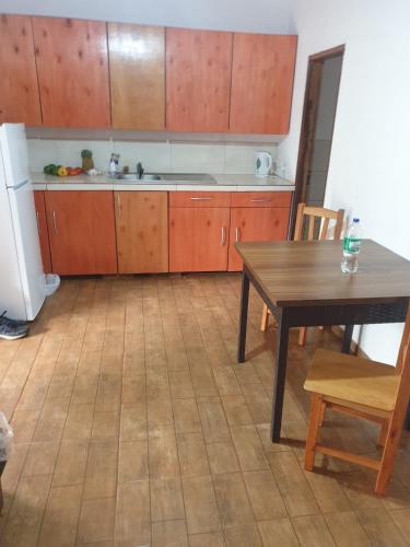 - une cuisine avec des placards en bois, une table, une table et des chaises dans l'établissement Wall Apartamentos, à Hohenau