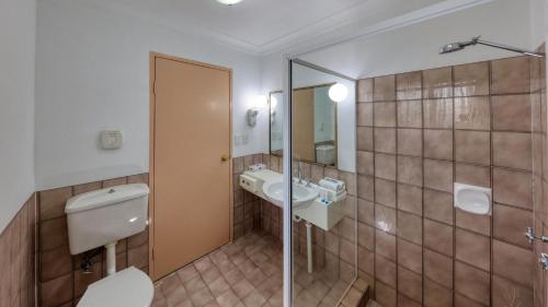 a bathroom with a toilet and a sink at Southern Comfort Motor Inn in Cootamundra