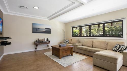 a living room with a couch and a table at Mara Bello - Umina Beach in Umina