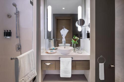 a bathroom with a sink and a mirror at Park Rotana Abu Dhabi in Abu Dhabi