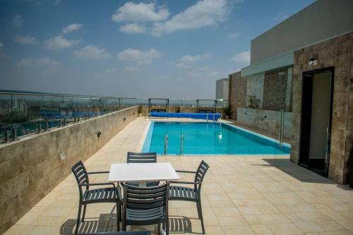 a table and chairs in front of a swimming pool at Elite Residences by Bednbeyond O72195O3I9 in Nairobi
