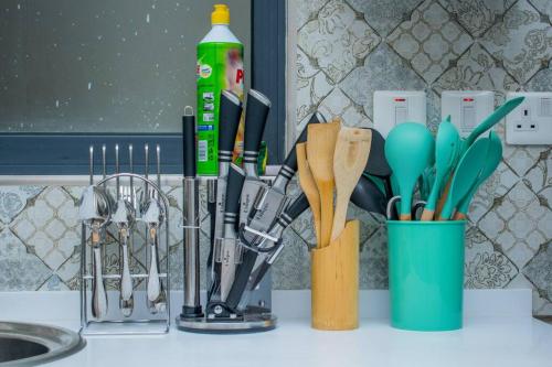 eine Küchentheke mit Küchenutensilien und einer Tasse Löffeln in der Unterkunft Elite Residences by Bednbeyond O72195O3I9 in Nairobi