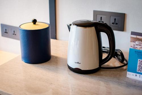 a black and white tea kettle on a counter at Golden Tulip FAB Hotel New Taipei in Tamsui