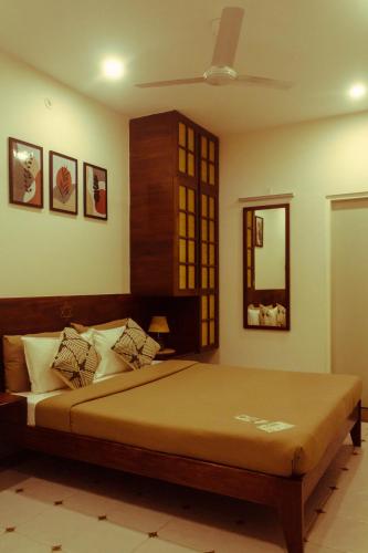 a bedroom with a bed and a mirror at Casa Mel in Puducherry