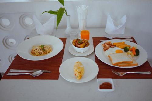 a table with plates of breakfast food on it at Montagne Regency in Kampot