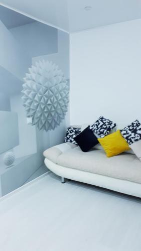 um quarto branco com uma cama e um espelho em Апартаменты с шикарным видом на море em Aktau