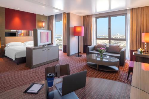 a hotel room with a bed and a television at Park Rotana Abu Dhabi in Abu Dhabi