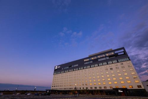 ein hohes Gebäude mit blauem Himmel im Hintergrund in der Unterkunft The358 UMI in Fukuoka