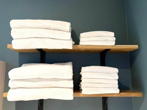 a stack of towels on a shelf in a bathroom at studio Symphonia x Fukutsu in Fukuma