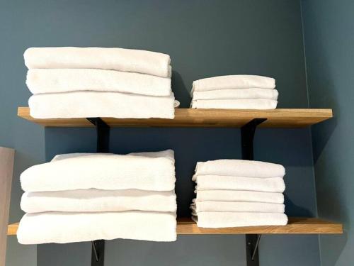 a stack of towels on a shelf in a bathroom at studio Symphonia x Fukutsu 