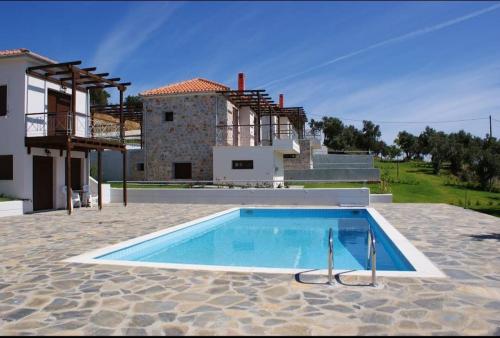 a swimming pool in front of a house at Melro in Skiathos