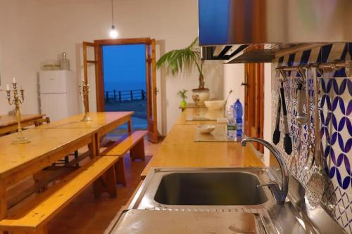 eine Küche mit einer Spüle und einer Theke mit einem Tisch in der Unterkunft Villa Timpone in Guardavalle