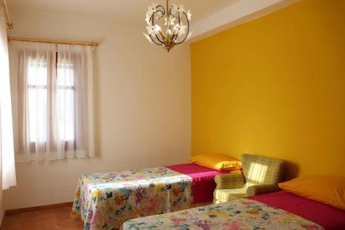 Habitación con 2 camas, mesa y lámpara de araña. en Villa Timpone, en Guardavalle