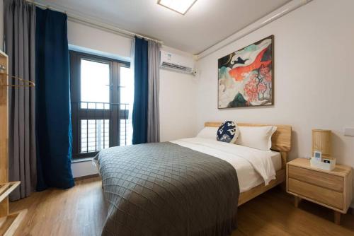 a bedroom with a bed and a large window at WESU Weisu Executive Apartment Shenzhen Shenda Metro Store in Shenzhen