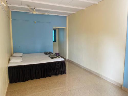 a room with a bed in the corner of a room at Coco land - Near Nagaon Beach, Alibag in Alibaug
