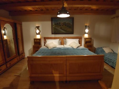 um quarto com uma grande cama de madeira e 2 candeeiros em POČITNIŠKA HIŠA PRLEČKA em Miklavž pri Ormožu