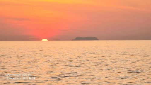 a sunset over the ocean with an island in the distance at Lanta Amara Resort in Ko Lanta