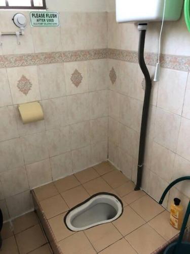 a bathroom with a toilet in the floor of a stall at irdahusna homestay in Rasa