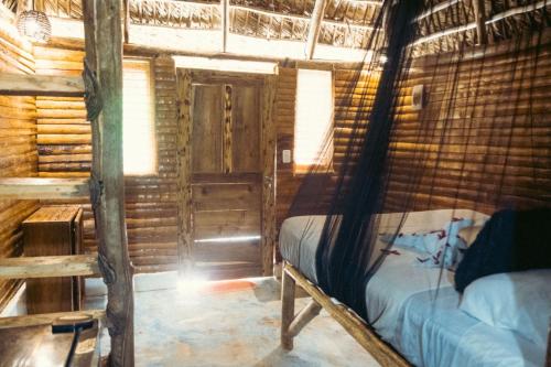 um quarto com uma cama num chalé de madeira em Valle Bucana em Santa Bárbara de Samaná