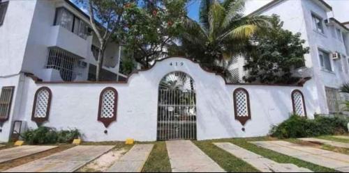 un edificio blanco con una puerta y una palmera en Bonita casa Moon Penthouse en Cancún, en Cancún