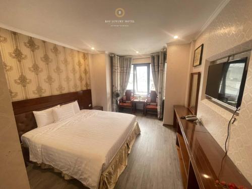 a hotel room with a bed and a flat screen tv at Ngoc Lan 1 Hotel HN - by BAY LUXURY in Hanoi