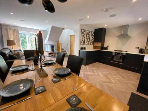 a dining room with a table and a kitchen at Cornish country getaway in Callington