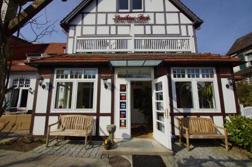 ein Gebäude mit zwei Stühlen davor in der Unterkunft Landhaus Bode in Travemünde