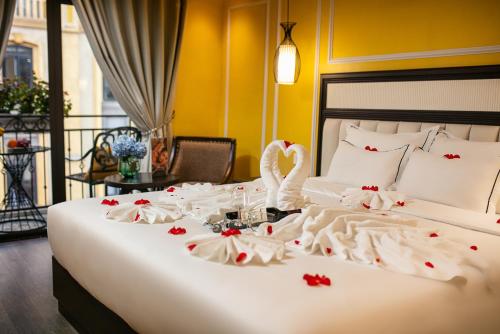 a bed with a swan on it with roses on it at Eden Central Hotel & Spa in Sa Pa