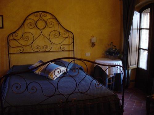 a bedroom with a bed with a wrought iron headboard at Agriturismo Il Macchione in Pienza