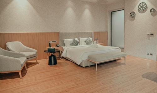 a bedroom with a large bed and two chairs at Pushkara Resort and Spa, Pushkar in Pushkar