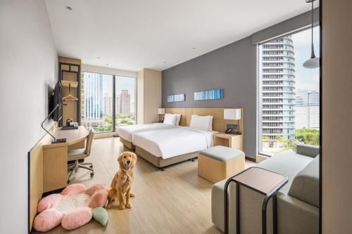 a bedroom with two beds and a dog in it at Hyatt Place New Taipei City Xinzhuang in Xinzhuang