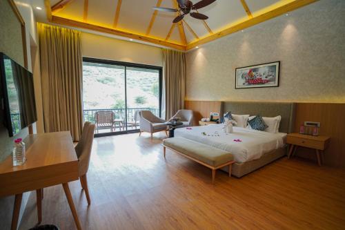 ein Schlafzimmer mit einem Bett, einem Tisch und einem Sofa in der Unterkunft Pushkara Resort and Spa, Pushkar in Pushkar