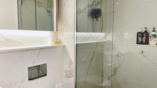 a bathroom with a shower with a glass door at Sweet Home Apartment North Melbourne in Melbourne