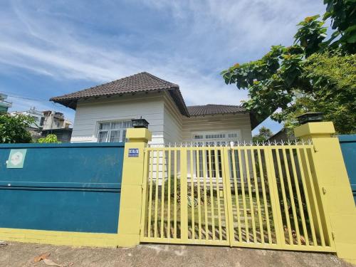une porte jaune devant une maison dans l'établissement Mon House, à Bảo Lộc