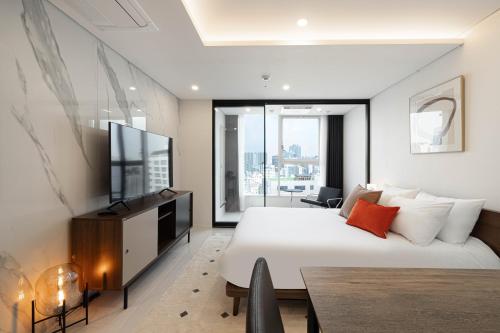 a bedroom with a large bed and a television at Le Collective Gangnam SAC Signity in Seoul