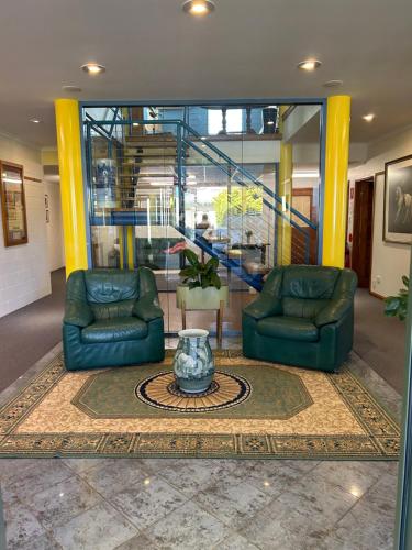 a lobby with two chairs and a vase on a rug at Whitemore B&B 