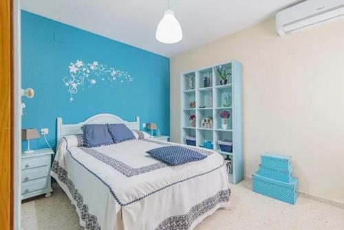 - une chambre bleue avec un lit et un mur bleu dans l'établissement Apartamento tranquilo en Granada para 6 personas, à Grenade