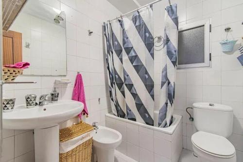 a white bathroom with a sink and a toilet at Apartamento tranquilo en Granada para 6 personas in Granada