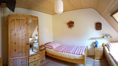 a bedroom with two beds and a mirror at Eule ost und west Ferienhaus im urigen Garten in Zingst