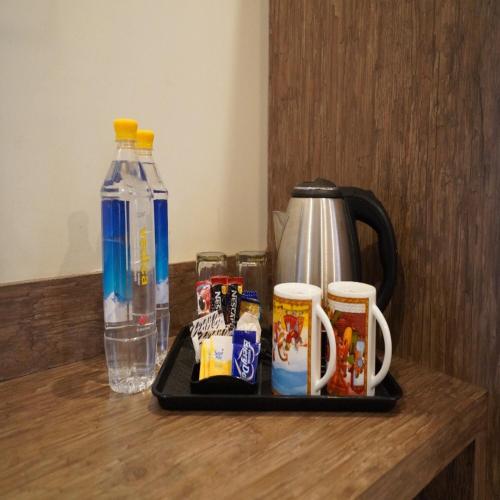 a tray with cups of coffee on a counter with drinks at Hotel The Omaira in Jaipur