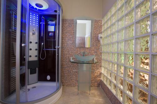 uma casa de banho com um chuveiro e um lavatório. em Hotel Bow Garden em Komárno