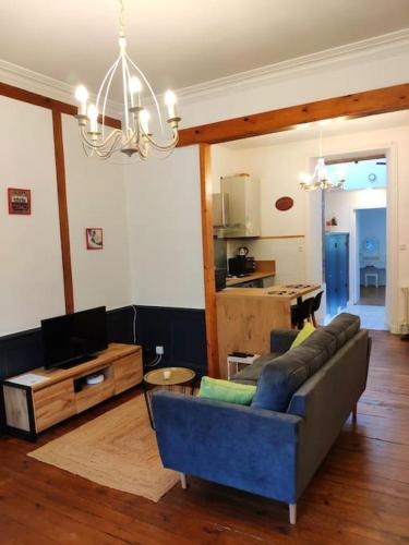 un salon avec un canapé bleu et une table dans l'établissement Logement entier 50 m² proche centre ville, à Morlaix