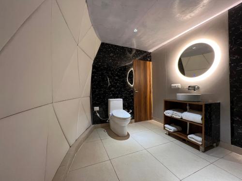 a bathroom with a toilet and a mirror at GLAMPING CLUB in Manāli