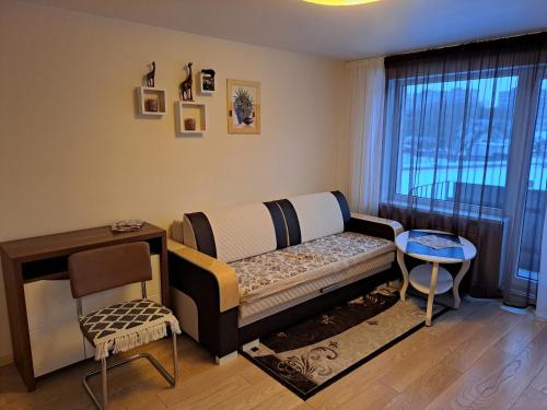 una camera con un letto, un tavolo e una finestra di Lubānas apartamenti a Rēzekne