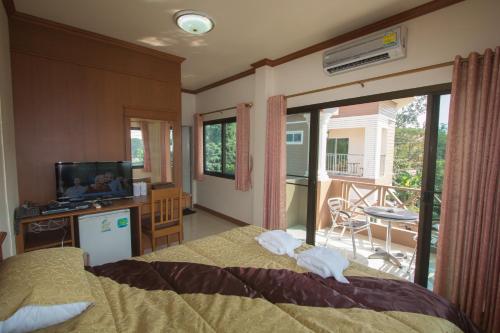a bedroom with a bed and a television and a balcony at Donchai House Guest House& Cafe in Chiang Mai