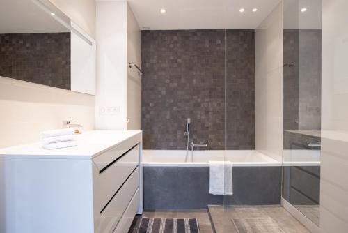 uma casa de banho com uma banheira, um lavatório e um chuveiro em Cannes Panorama - Piscine, vue mer, parking, clim em Cannes